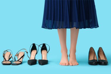 Mavi arka planda farklı stil yüksek topuklu genç bir kadının bacakları.