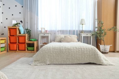 İçinde yatak, masa ve oyuncaklar olan çocuk odası.