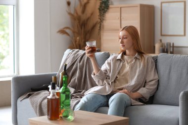 Evde viski içen genç bir kadın. Alkolizm kavramı