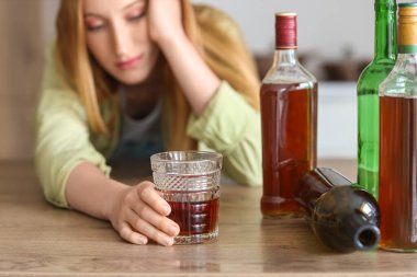 Evde alkol alan genç bir kadın. Alkolizm kavramı