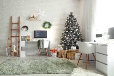 Masaları, Noel ağacı ve hediyeleri olan programcı ofisinin içi.
