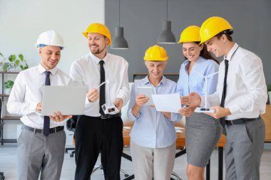 Rüzgâr türbini modelleri ve cihazları olan bir grup mühendis ofiste.