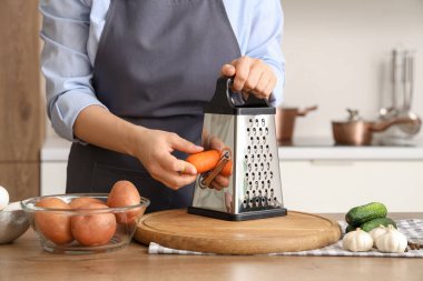 Mutfakta havuç rendeleyen kadın, yakın plan.