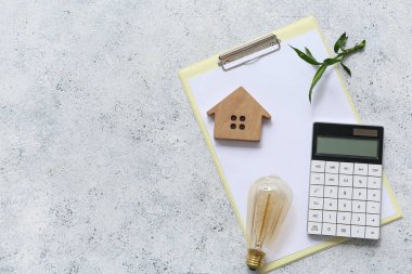 Ev figürlü pano, bitki, hesap makinesi ve Grunge arka planında ampul. Yeşil Enerji kavramı