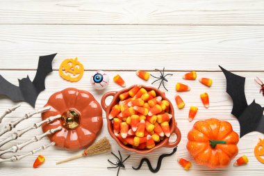 Beyaz ahşap arka planda oyuncaklarla ve şekerlerle Cadılar Bayramı kompozisyonu