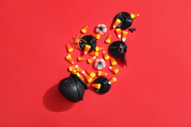 Kırmızı arka planda Cadılar Bayramı için esrarlı ve şekerli kompozisyon