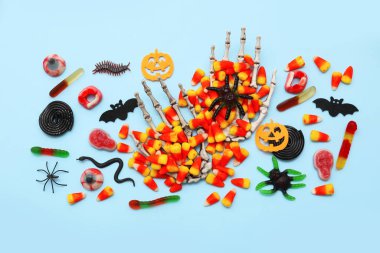 İskelet elli kompozisyon ve Cadılar Bayramı için farklı tatlılar.