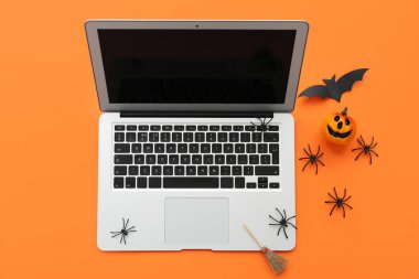 Renkli arka planda modern dizüstü bilgisayar ve Cadılar Bayramı için dekorasyon kompozisyonu