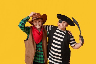 Cadılar Bayramı partisi için sarı arka planda kılıçlı şirin çocuklar.