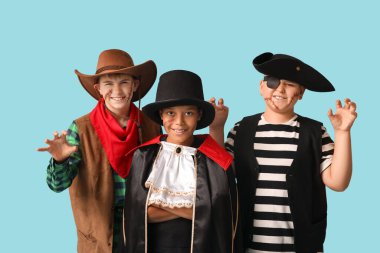 Cadılar Bayramı partisi için mavi arka planda farklı kostümler içinde şirin, mutlu çocuklar.