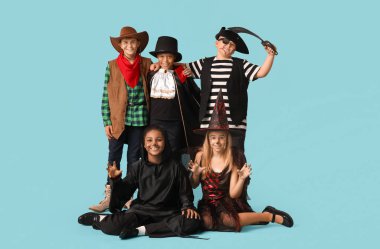 Cadılar Bayramı partisi için mavi arka planda farklı kostümler içinde şirin mutlu çocuklar.