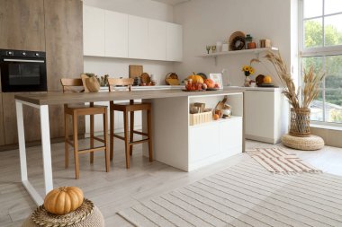 Balkabağı, böğürtlen ve sonbahar dekorasyonlarıyla aydınlık mutfağın içi