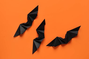 Cadılar Bayramı partisi için turuncu arka planda siyah kağıt yarasalar