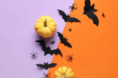 Renkli arka planda Cadılar Bayramı partisi için örümcekli kağıt yarasalar ve taze balkabakları.