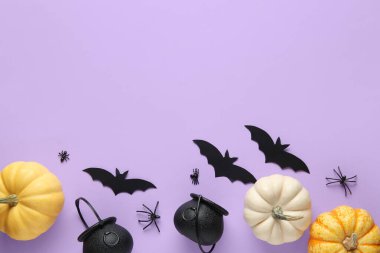 Cadılar Bayramı partisi için arkaplanda örümcekler, kazanlar ve taze balkabakları olan kağıt yarasalar.