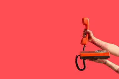 Kırmızı arka planda telefonu olan zombi eller. Cadılar Bayramı