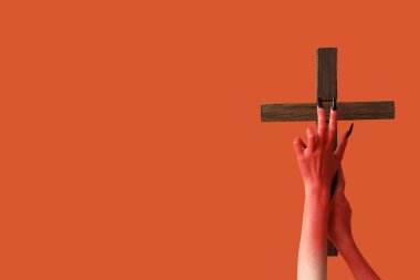 Turuncu arka planda ahşap haçlı şeytan elleri. Cadılar Bayramı