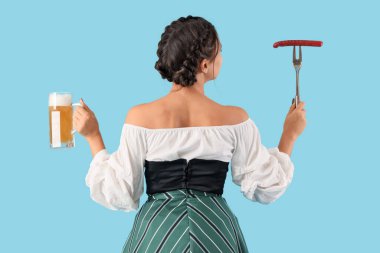 Mavi arka planda bira ve sosisli genç Ekim Festivali garsonu.