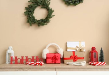 Koridordaki bej duvarın yanındaki klozette kulaklık ve dekorla Noel hediyeleri.