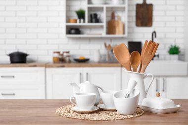 Porselen çaydanlık, fincanlar, harç ve tokmak mutfaktaki tahta tezgahta.