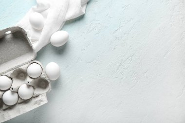 Açık mavi arka planda çiğ tavuk yumurtası.