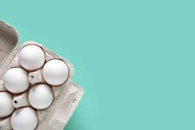 Turkuaz arka planda çiğ tavuk yumurtası.