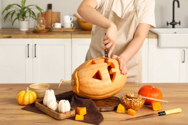 Mutfakta tezgahta balkabağı oyan kadın.