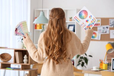 Ofiste renk paletleri olan kadın web tasarımcısı, arka plan