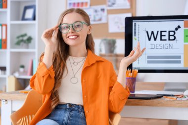 Ofisteki masanın yanında oturan kadın web tasarımcısı