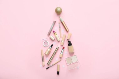 Makyaj ürünlerinden yapılmış Noel ağacı ve pembe arka planda süslemeler