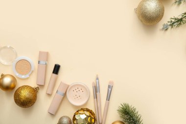 Bej arka planda farklı makyaj ürünleri olan güzel Noel süsleri.