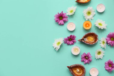Çiçekli Diya lambaları ve turkuaz arka planda mumlar. Divaly kutlaması