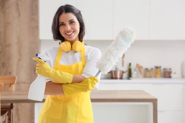 Mutfakta pp-toz bezi ve deterjanı olan kadın hademe.