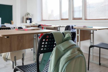 Boş sınıfta sırt çantalı okul başkanı.