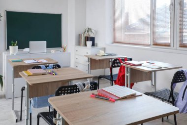 Okul sıraları ve yeşil panolu boş sınıfın içi