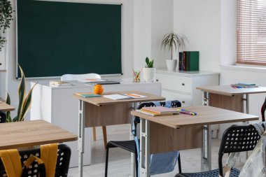 Okul sıraları ve yeşil panolu boş sınıfın içi