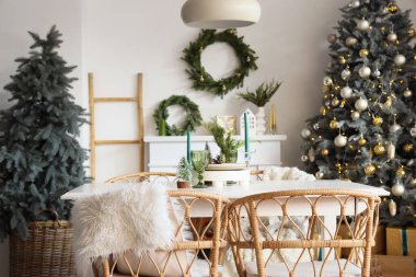 Mum dolu yemek masası ve aydınlık odada Noel süsü.