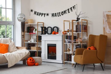 Cadılar Bayramı için koltuk, disko topu, şömine ve balkabaklarıyla dekore edilmiş oturma odasının içi.