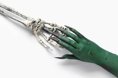 İskelet ve yeşil cadının elleri beyaz arka planda izole edilmiş. Cadılar Bayramı