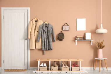 Trençkotlu askı, raf ünitesi ve aksesuarlar koridorda.