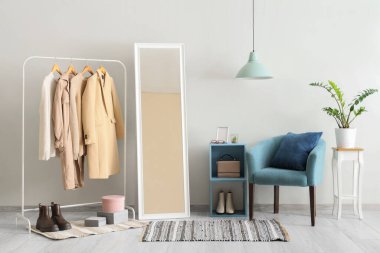 Koridorun iç tarafında sonbahar kıyafetleri, ayna ve koltuk rafları var.