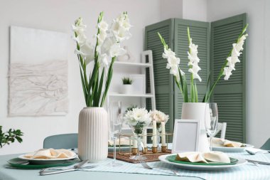 Beyaz Gladiolus çiçekleri ve yanan mumlarla dolu bir masa.