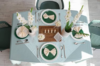 Beyaz Gladiolus çiçekli masa ayarı ve odada yanan mumlar, üst manzara