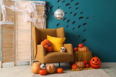 Cadılar Bayramı partisi için dekore edilmiş disko topu ve koltuklu şık bir oturma odası.