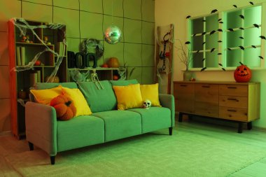 Cadılar Bayramı partisi için dekore edilmiş disko topu ve yumuşak kanepeli şık bir oturma odası.