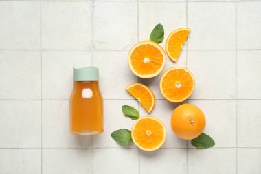 Spor şişe taze portakal suyu naneli ve beyaz fayanslı meyveler.
