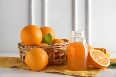 Bir şişe taze portakal suyu ve beyaz arka planda meyveler.