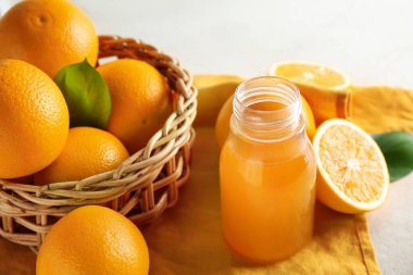 Bir şişe taze portakal suyu ve beyaz arka planda meyveler.