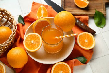 Beyaz fayanslı bir bardak taze portakal suyu ve tabak.