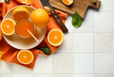 Beyaz fayanslı bir bardak taze portakal suyu ve tabak.